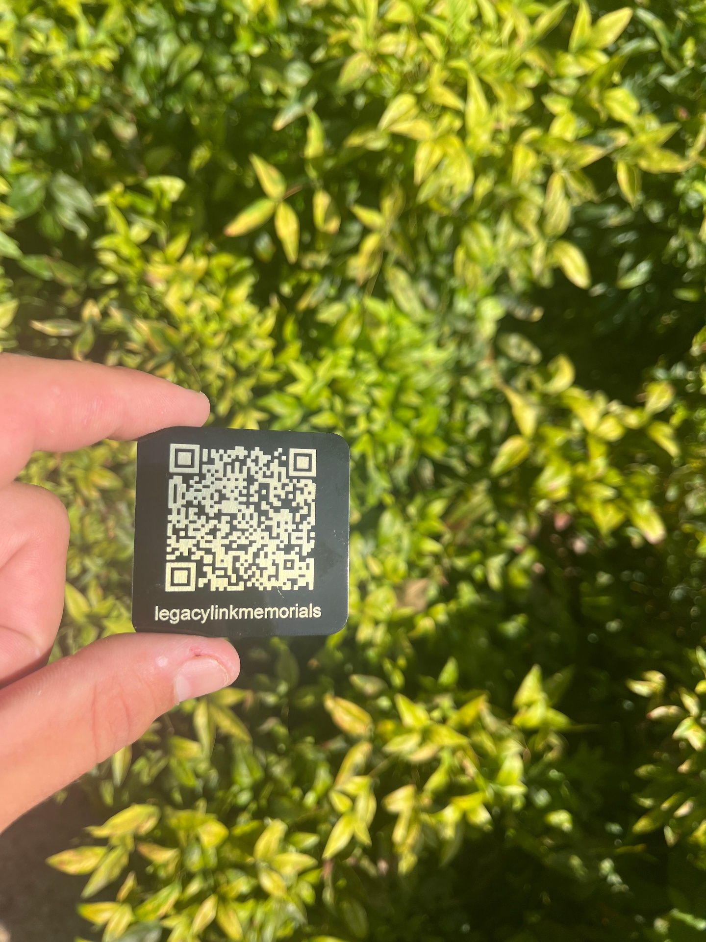 LegacyLink QR memorial plaque held in hand